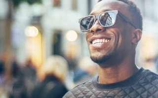 Man in sunglasses and black sweater grinning