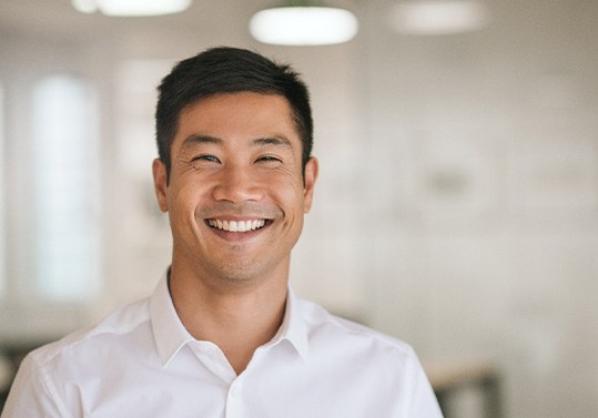 Man in white button-up shirt smiling