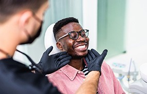 Dentist looking at patient’s smile in treatment room