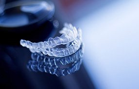 Invisalign trays on reflective dark surface