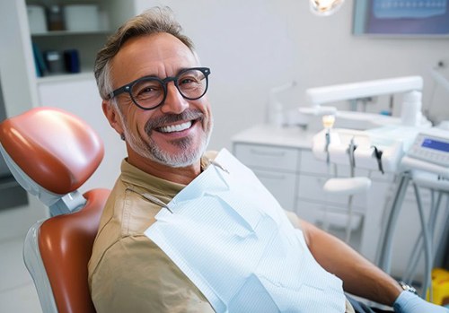 Smiling middle-aged man in dental treatment chair
