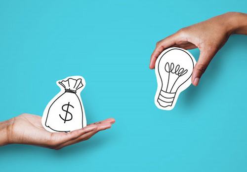 One hand holding a bag of money while the other holds a lightbulb 
