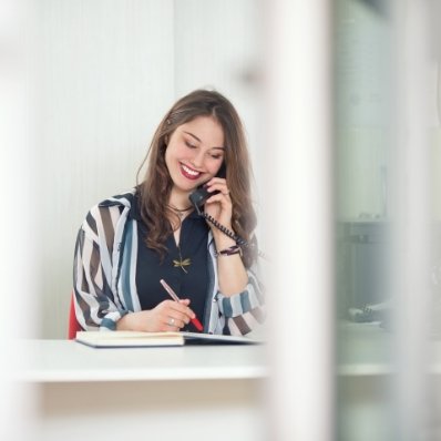 Fountain Valley dental team member smiling while talking on phone
