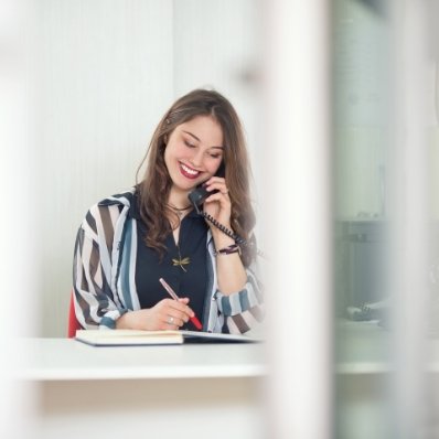 Smiling Fountain Valley dental team member talking on phone