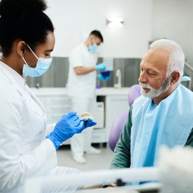 Dental patient signing form on clipboard