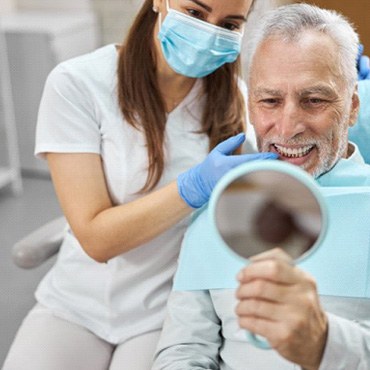 a patient checking his teeth with a mirror