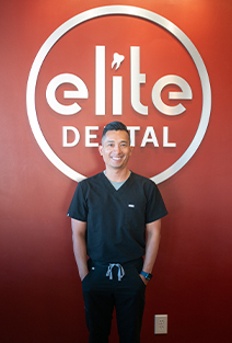 Dental team member in front of Elite Dental of Fountain Valley sign