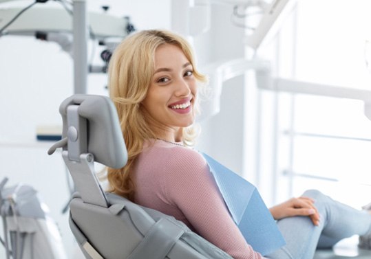 Dental patient in treatment chair, smiling happily