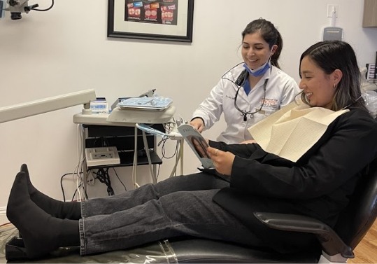 Doctor Saber showing a paper to a dental patient