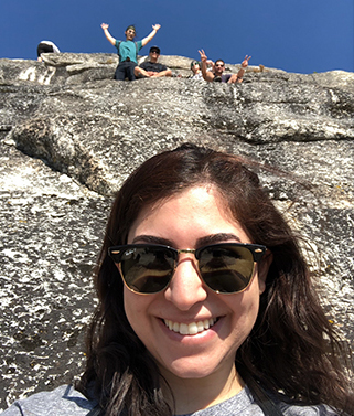 Selfie of Doctor Saber on a hike with a few people posing on rock ledge in background