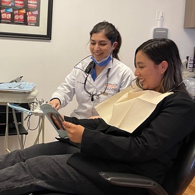 Doctor Saber showing a paper to a dental patient