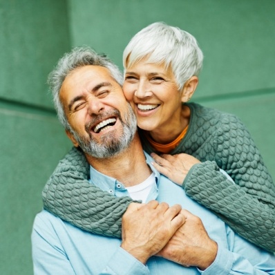 Senior man and woman smiling after replacing missing teeth in Fountain Valley