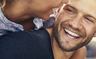 Close up of young man and woman laughing together outdoors