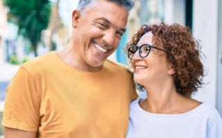 Man in yellow shirt smiling with woman in white blouse