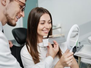 Patient looking at veneers in dental office. 