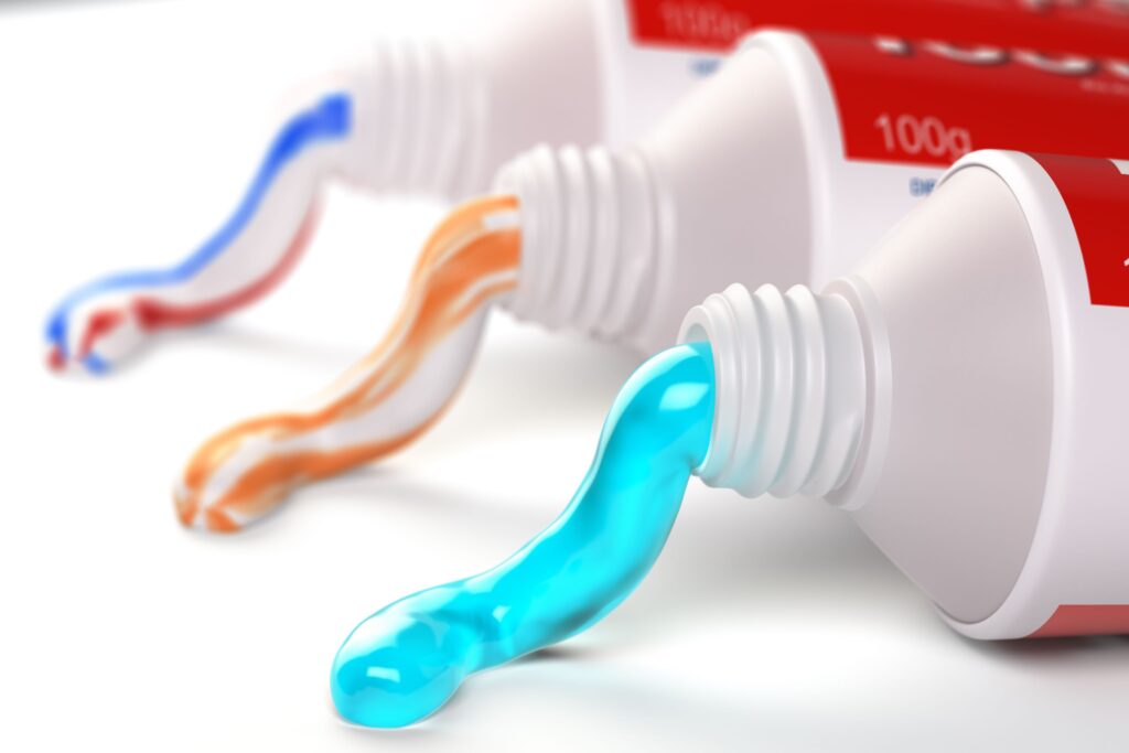 Three tubes of different types of toothpaste in a row