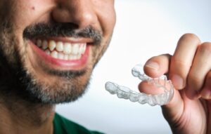 Man smiling with his Invisalign tray